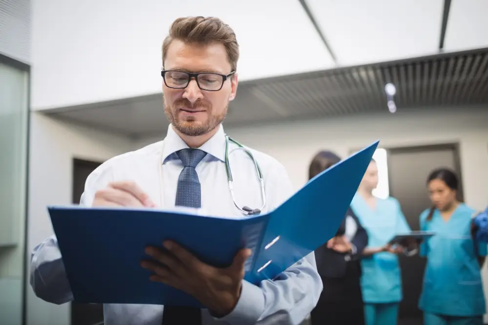 Healthcare claims auditor reviewing medical billing records to identify coding errors and ensure compliance. TFG Partners audits 100% of claims to catch upcoding.